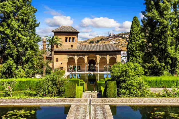 palazzo immerso nel verde con un laghetto davanti