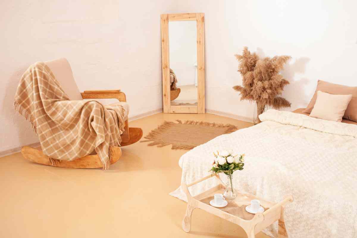 Camera da letto stile nordico con sedia a dondolo e specchio con cornice in legno chiaro