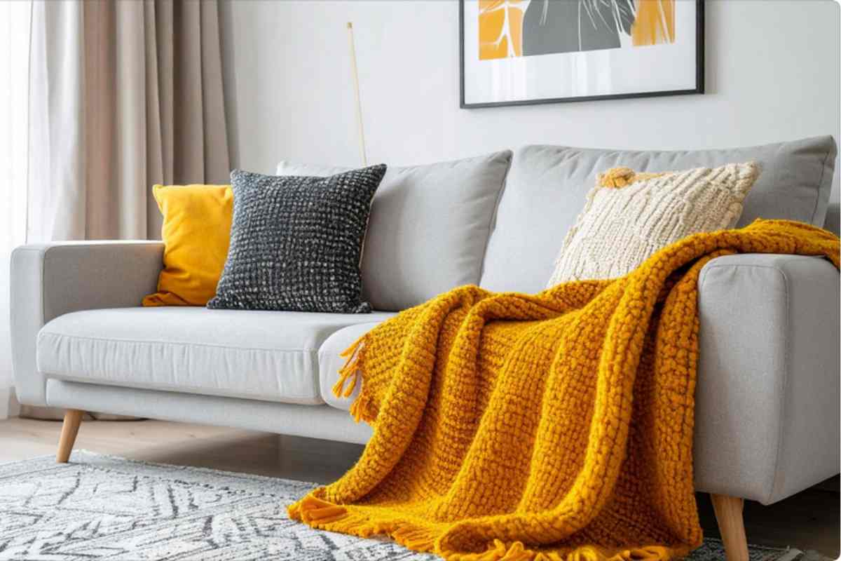 divano grigio con coperta ruggine