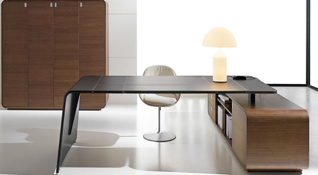 Scrivania in pelle di colore nero con piano d'appoggio in legno, con lampada bianca e mobile in legno sul retro