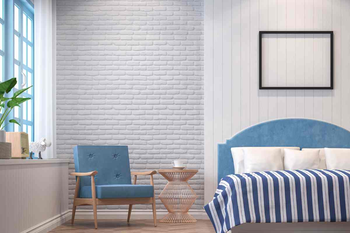 Camera da letto vintage con letto con testiera, poltroncina blu e copriletto a strisce