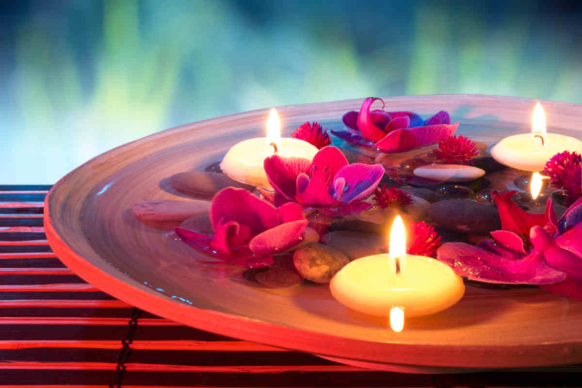 piatto di coccio con candele galleggianti e petali di fiori