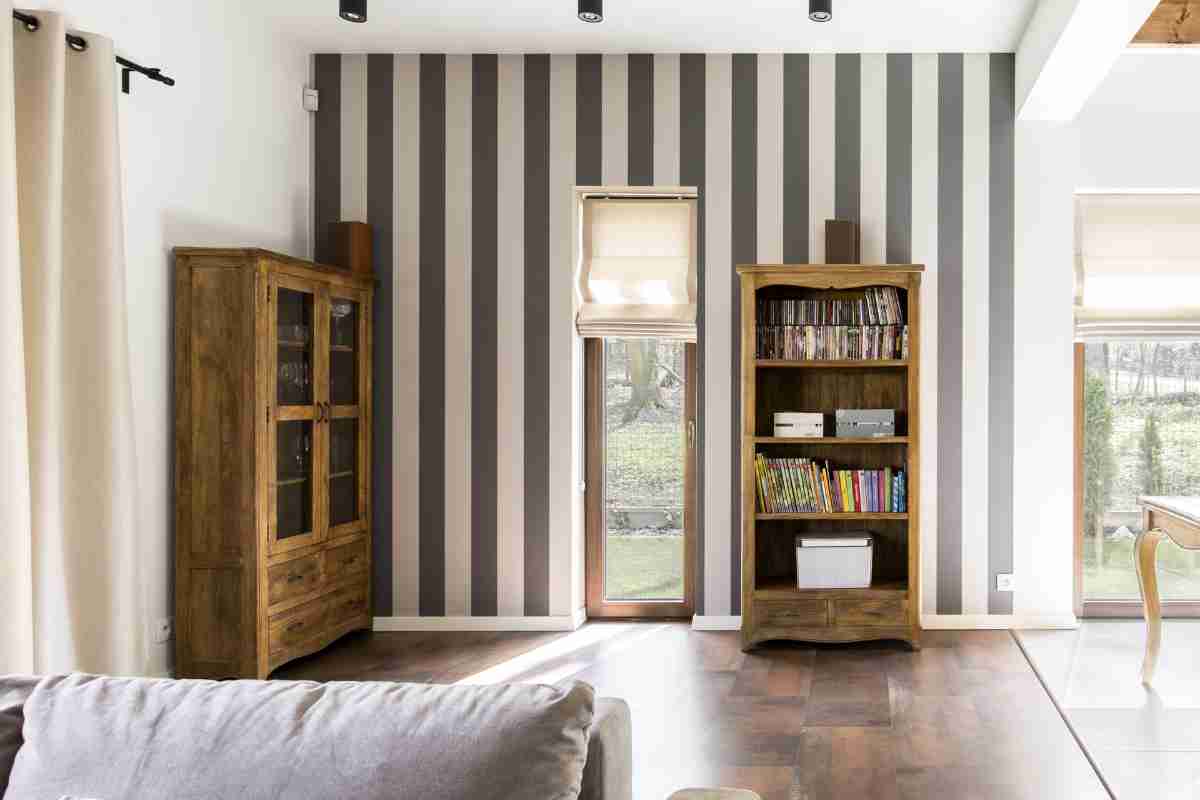 Carta da parati a righe in un soggiorno con credenza e libreria