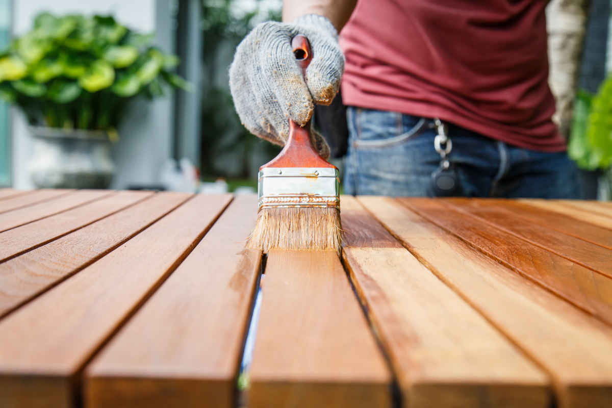 uomo dipinge un tavolo in legno