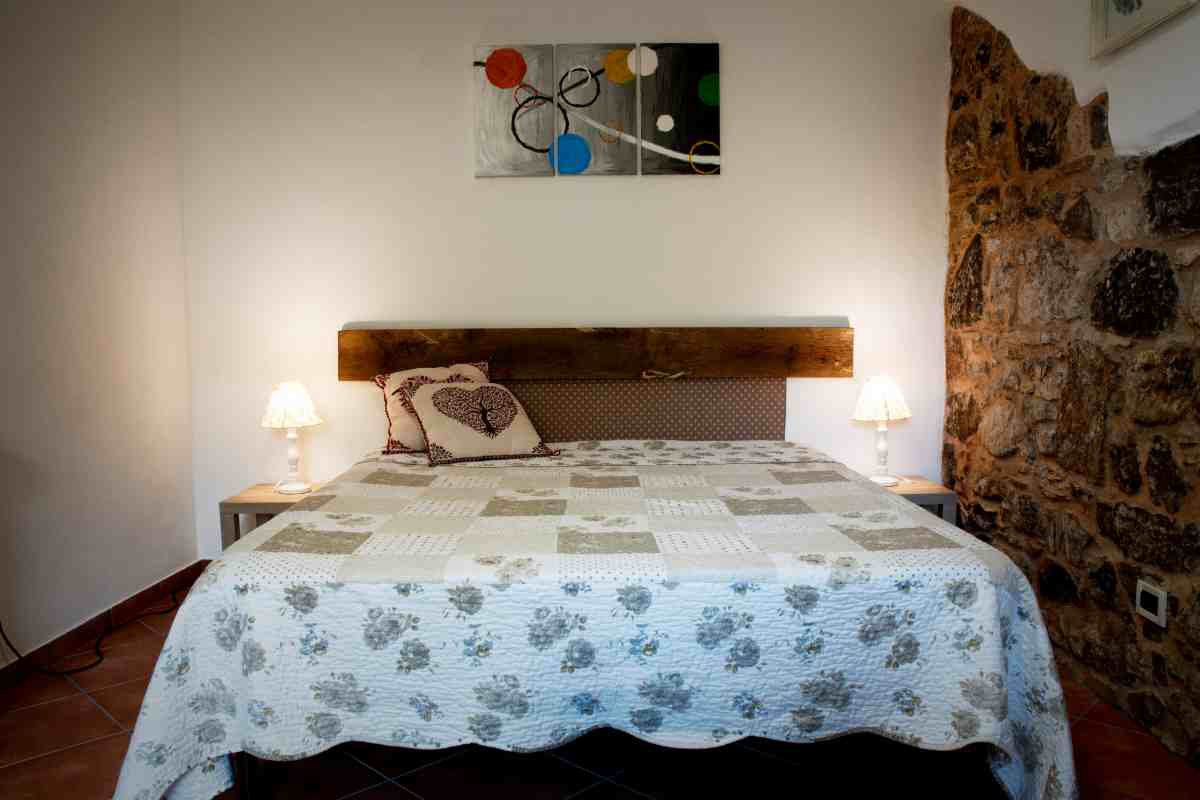 Camera da letto in taverna con muro di pietra