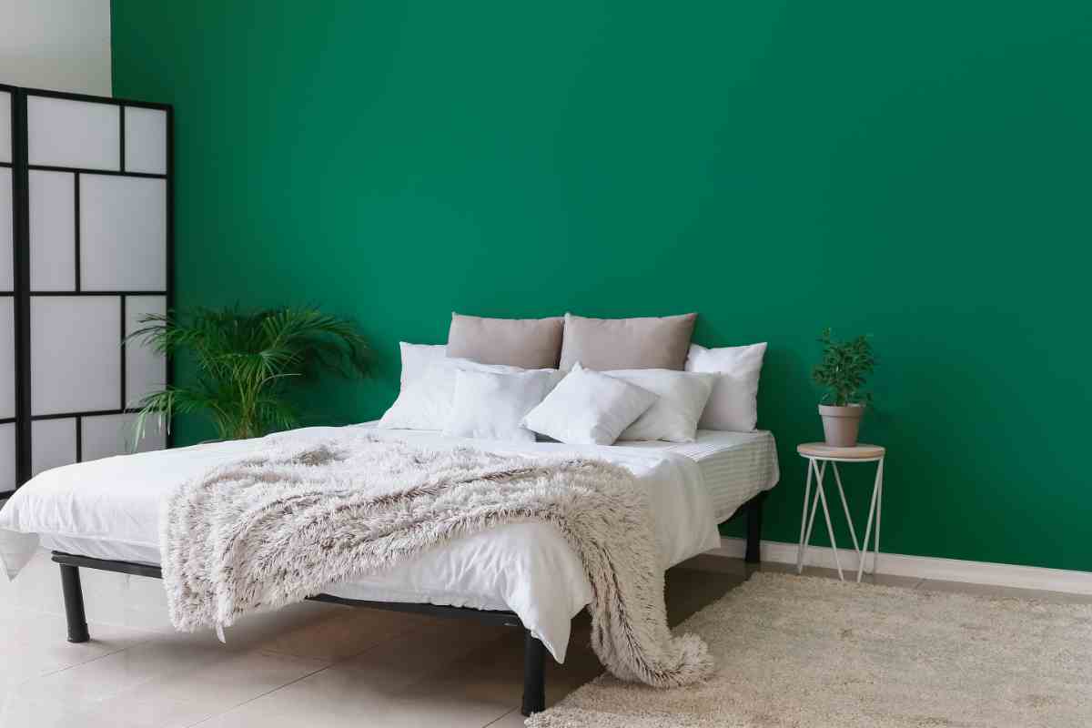 Camera da letto con parete verde smeraldo