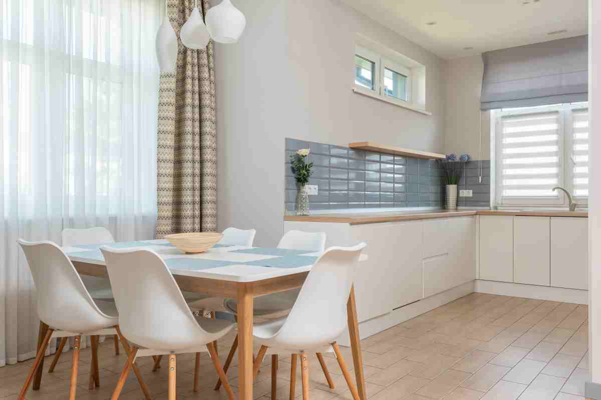 Cucina bianca e beige con tavolo e sedie stile nordico