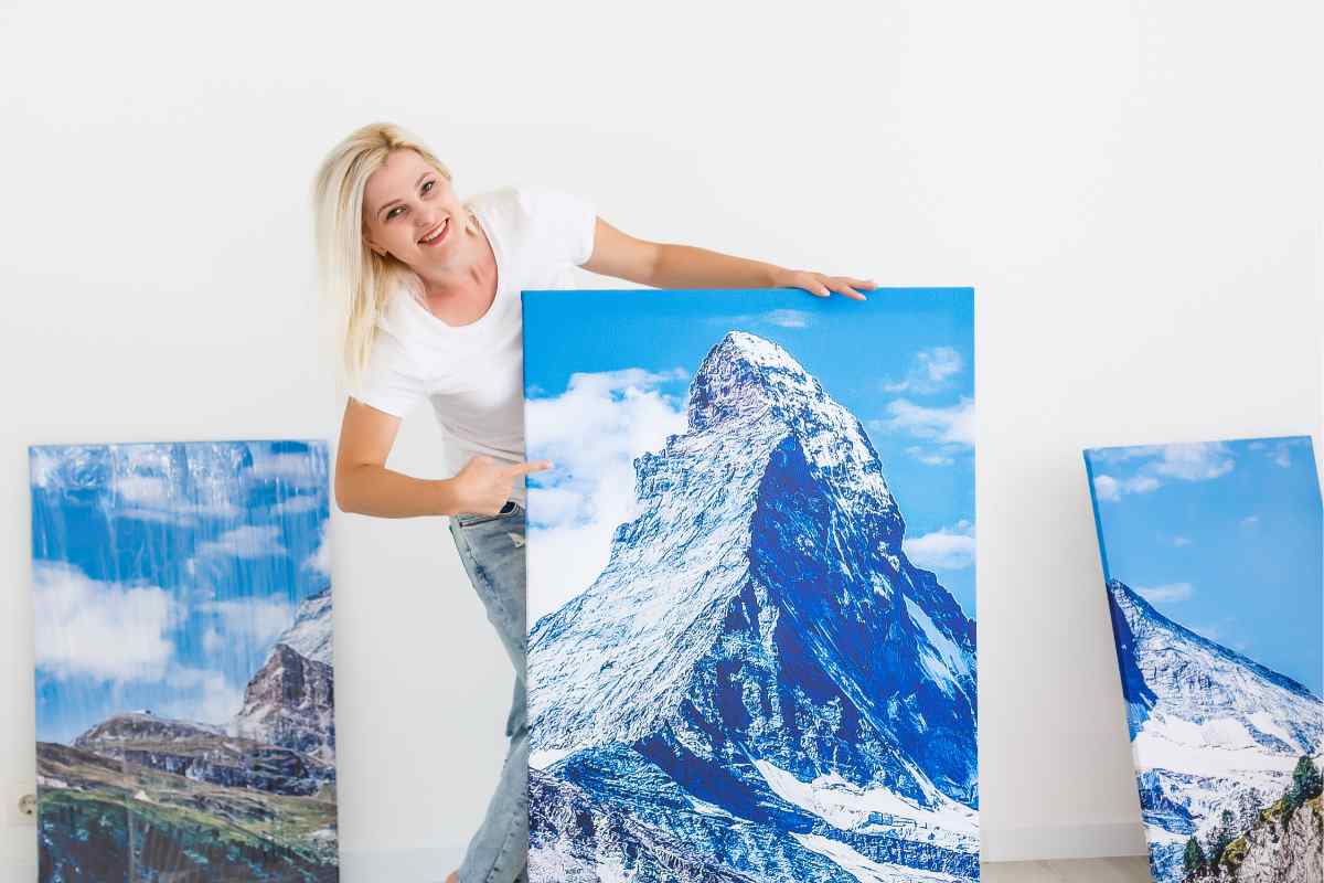 ragazza mostra le fotografie con cui andrà a decorare le pareti