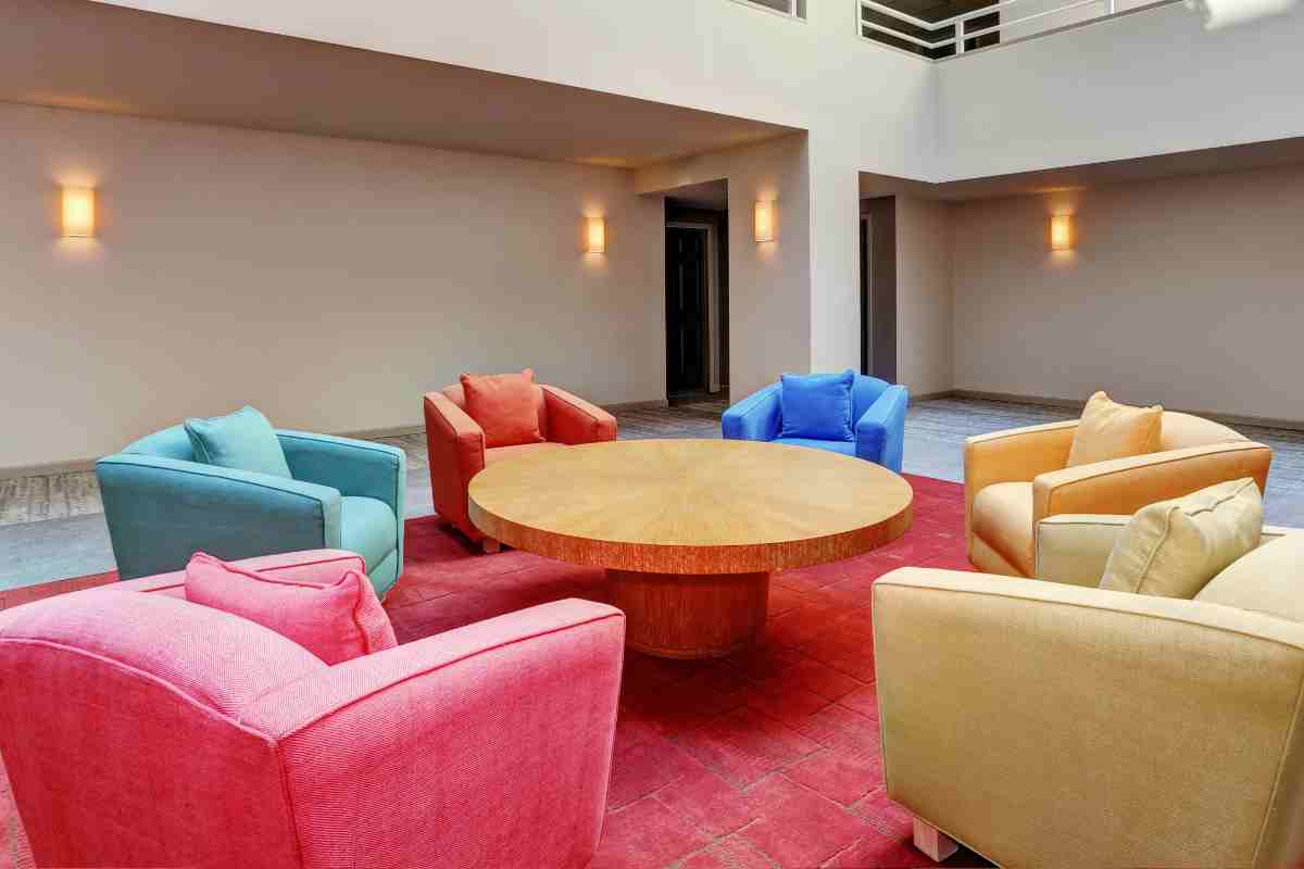 varie poltrone in diversi colori attorno a un tavolo rotondo