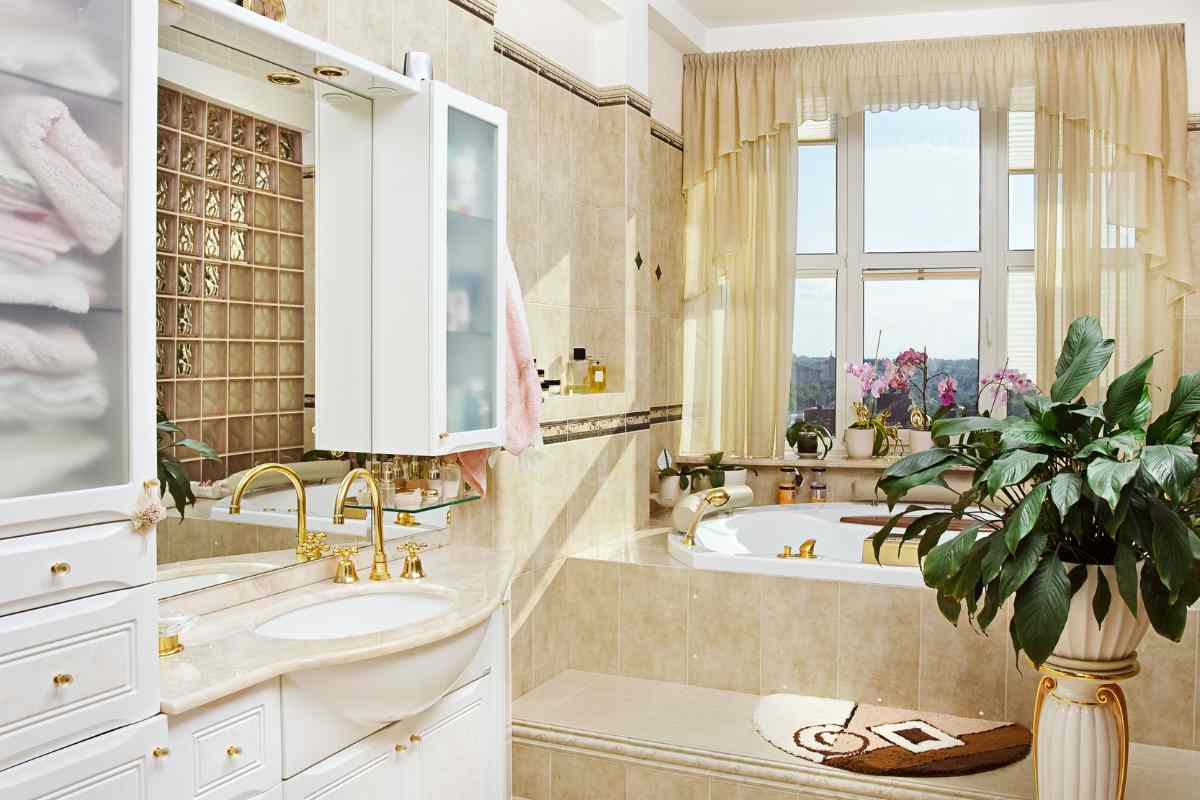Bagno stile romantico con mobili bianchi e rubinetteria dorata
