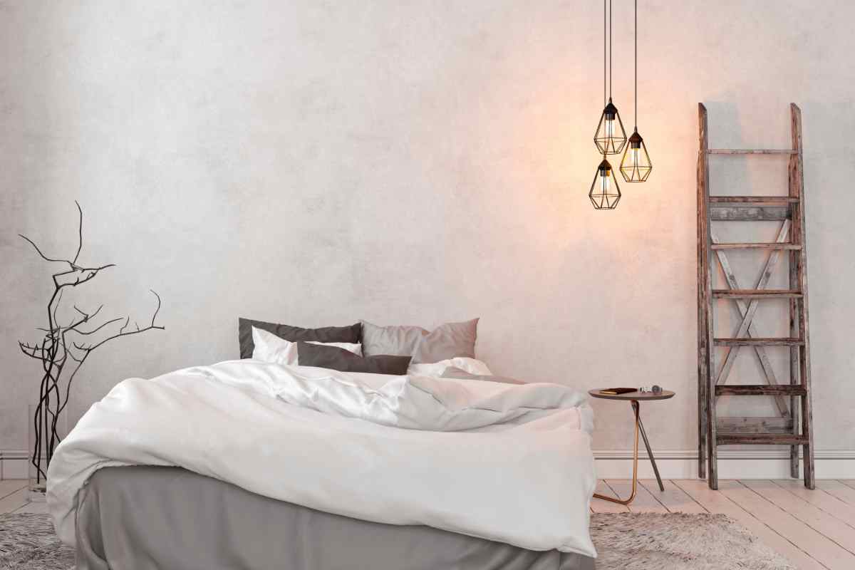 Camera da letto in stile scandinavo con scala in legno e vaso con rami secchi