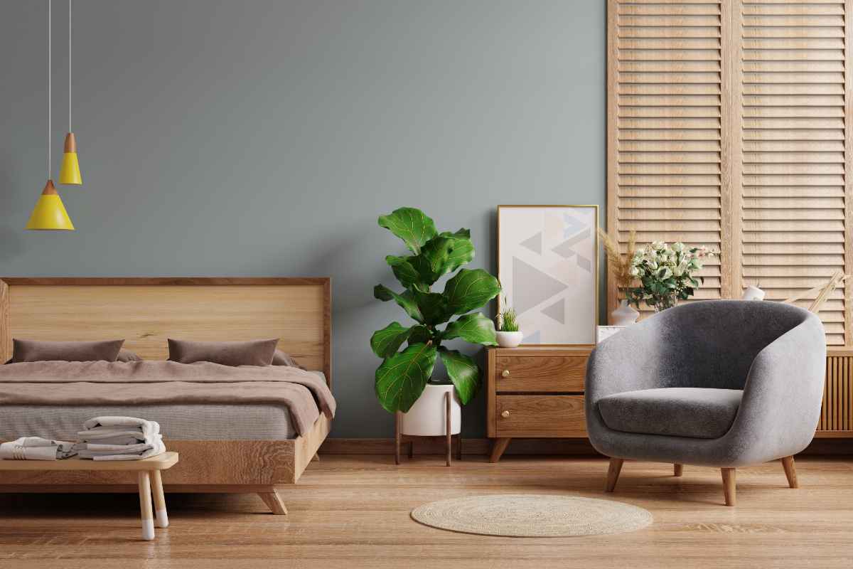 Camera da letto stile scandinavo con struttura del letto in legno e poltrona di colore grigio