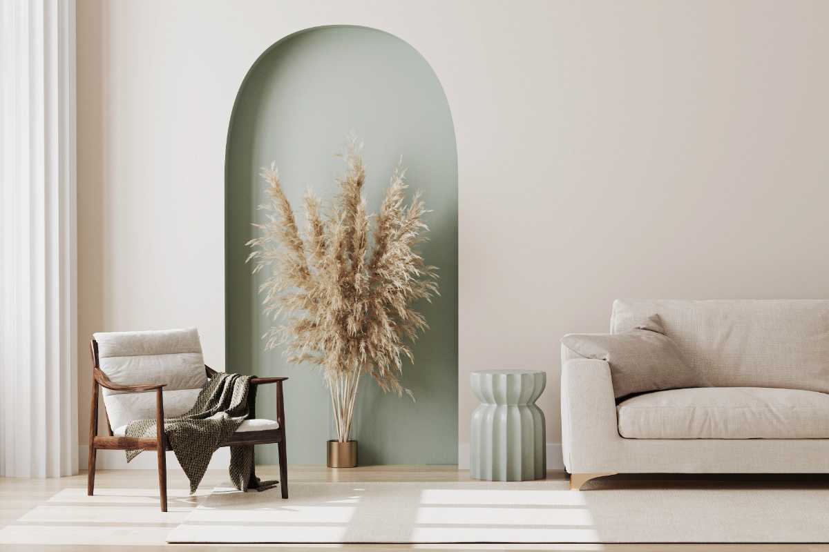 Un soggiorno con una nicchia ad arco in cartongesso sulla parete dietro al divano