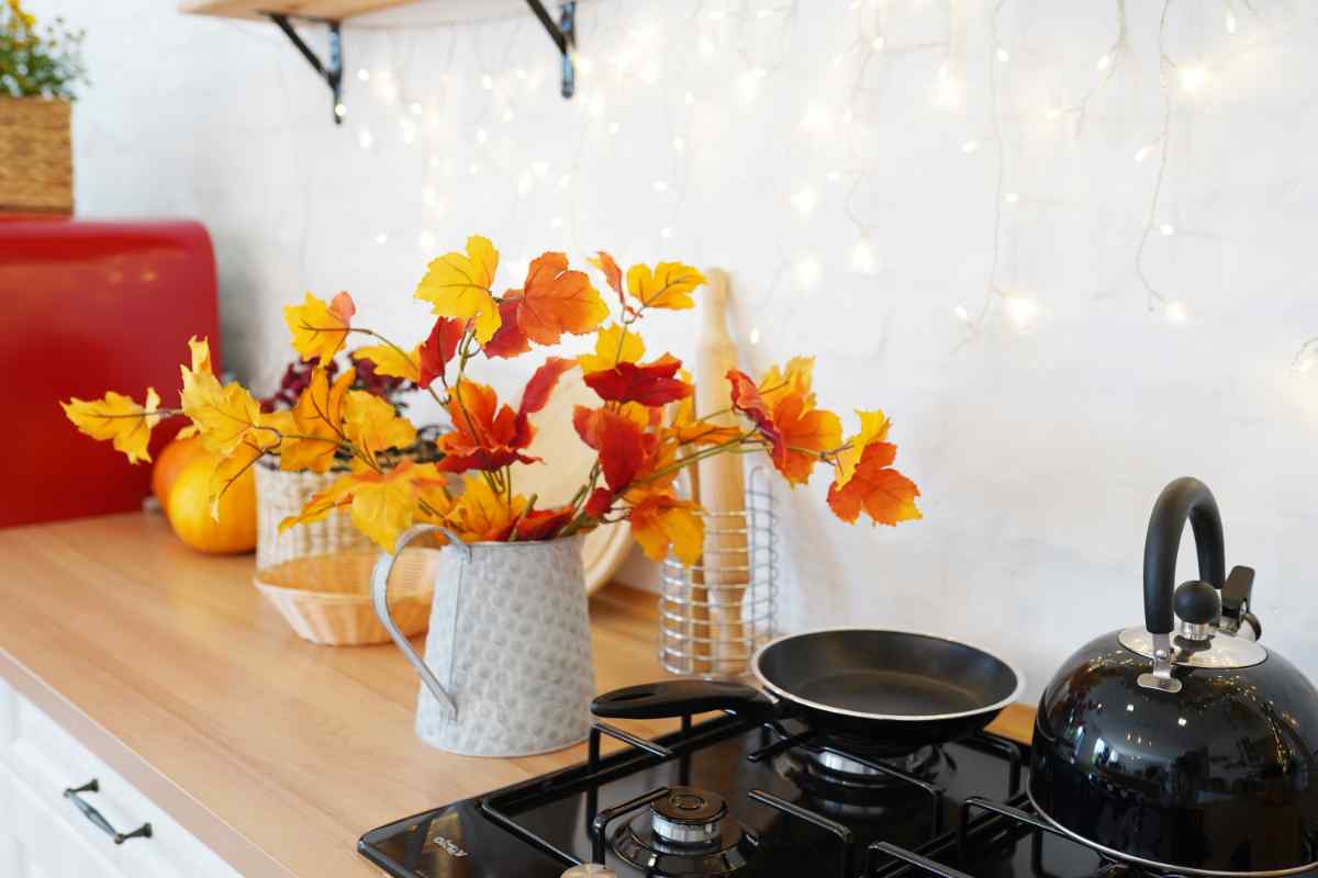 cucina abbellita con decorazioni autunnali, foglie colorate e luci