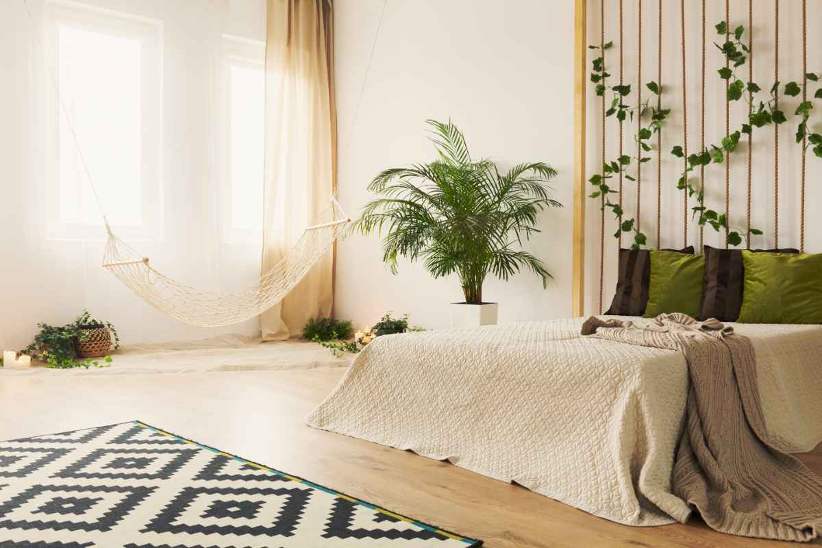 camera da letto color sabbia con piante e tappeto geometrico