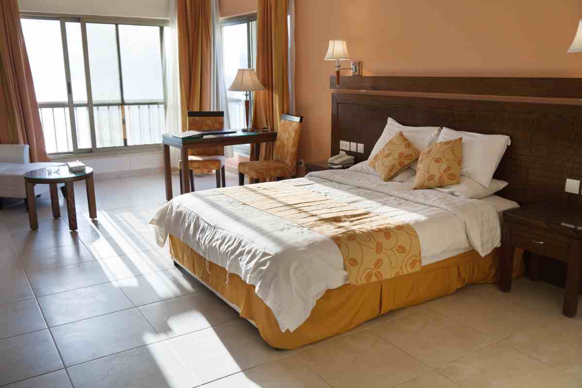 Camera da letto color sabbia con testata marrone scuro