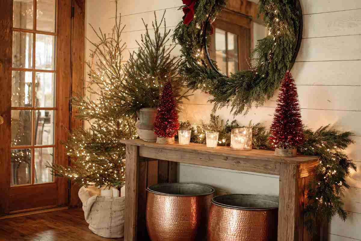 ingresso con tante decorazioni natalizie, ghirlande, alberi illuminati e candele