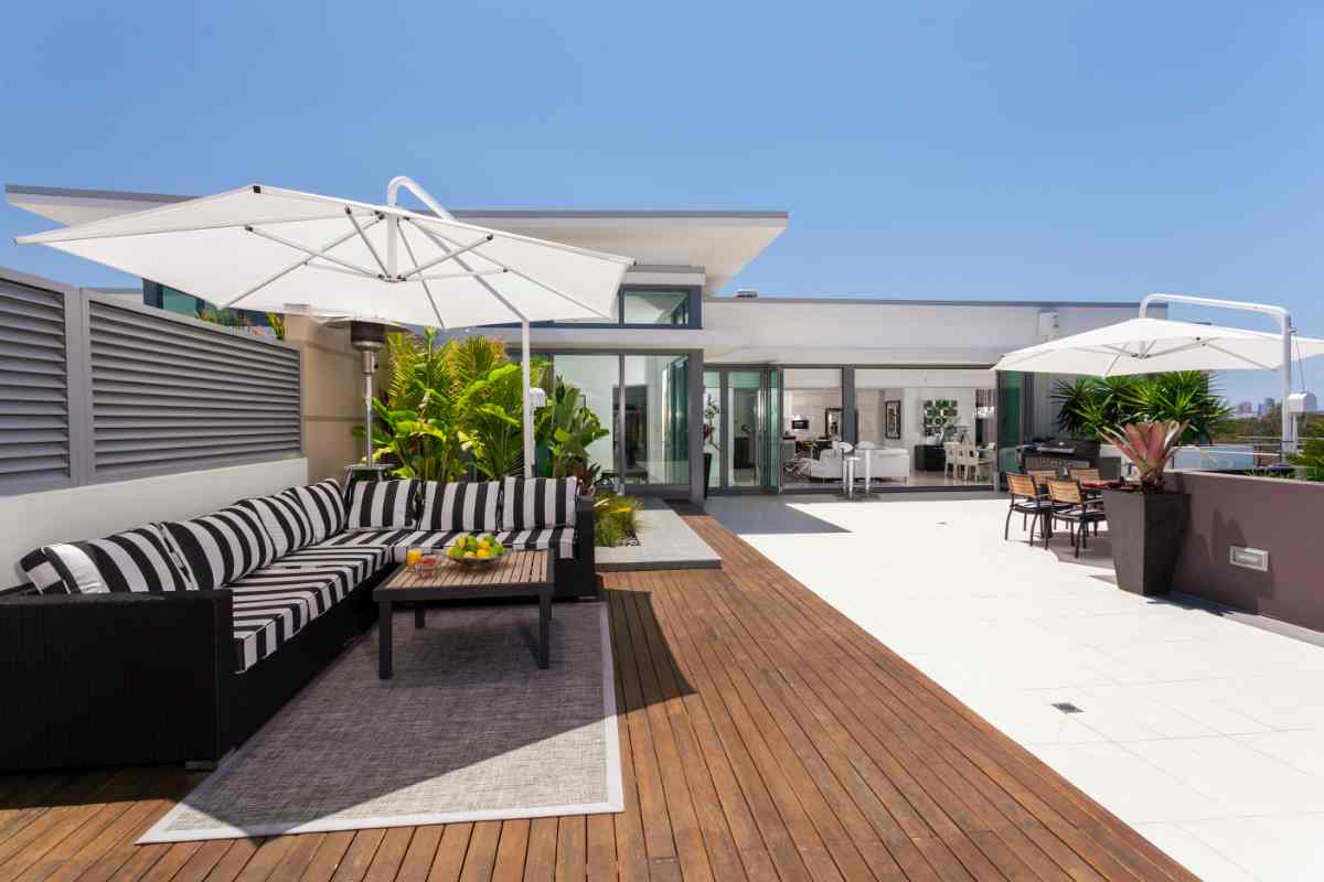 terrazzo su un attico di prestigio con divano angolare e zona pranzo ombreggiata
