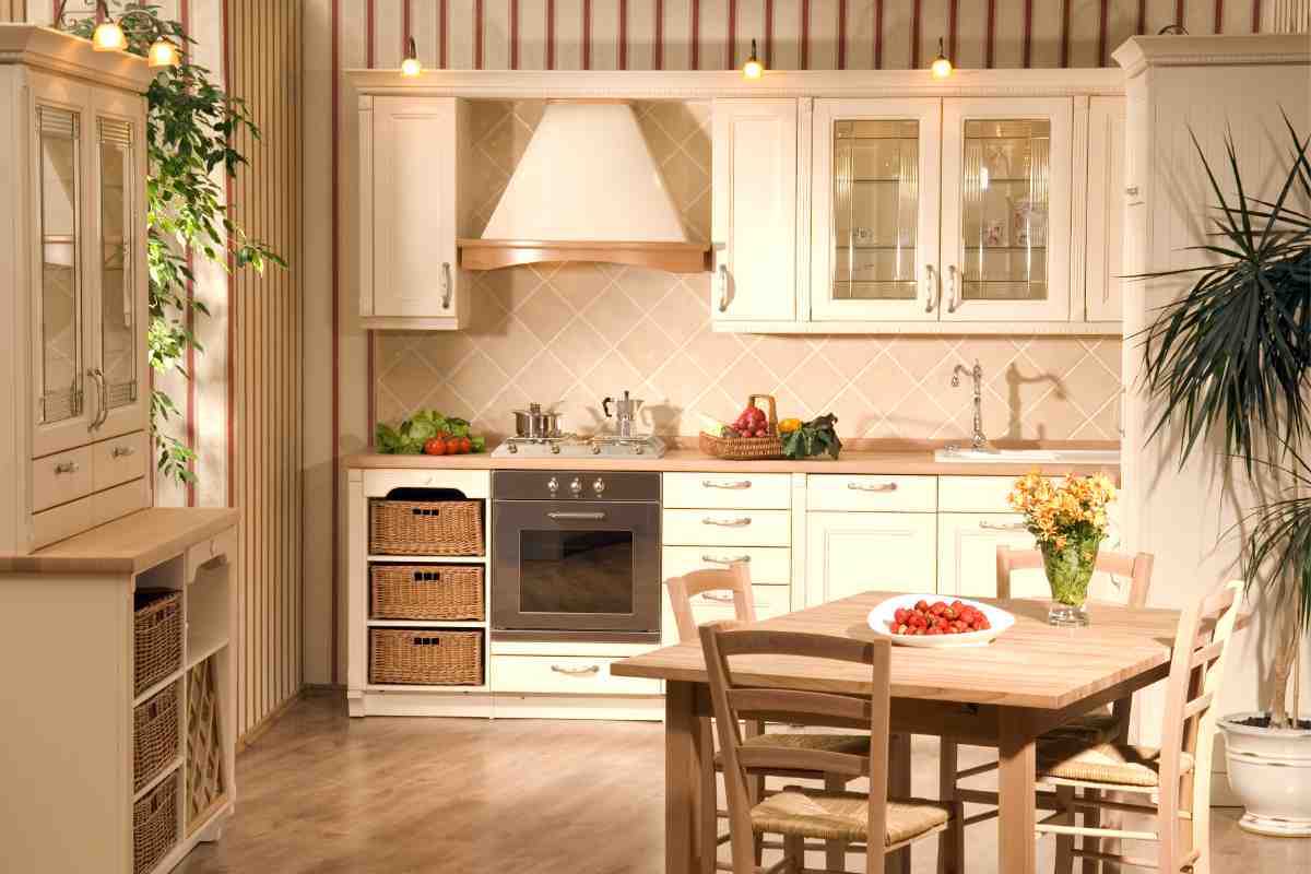una cucina in stile rustico nei toni del bianco con tavolo e sedie di paglia