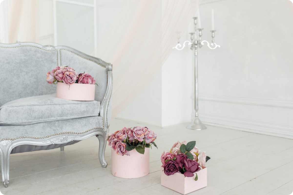 divano in salotto stile shabby chic con vasi di fiori