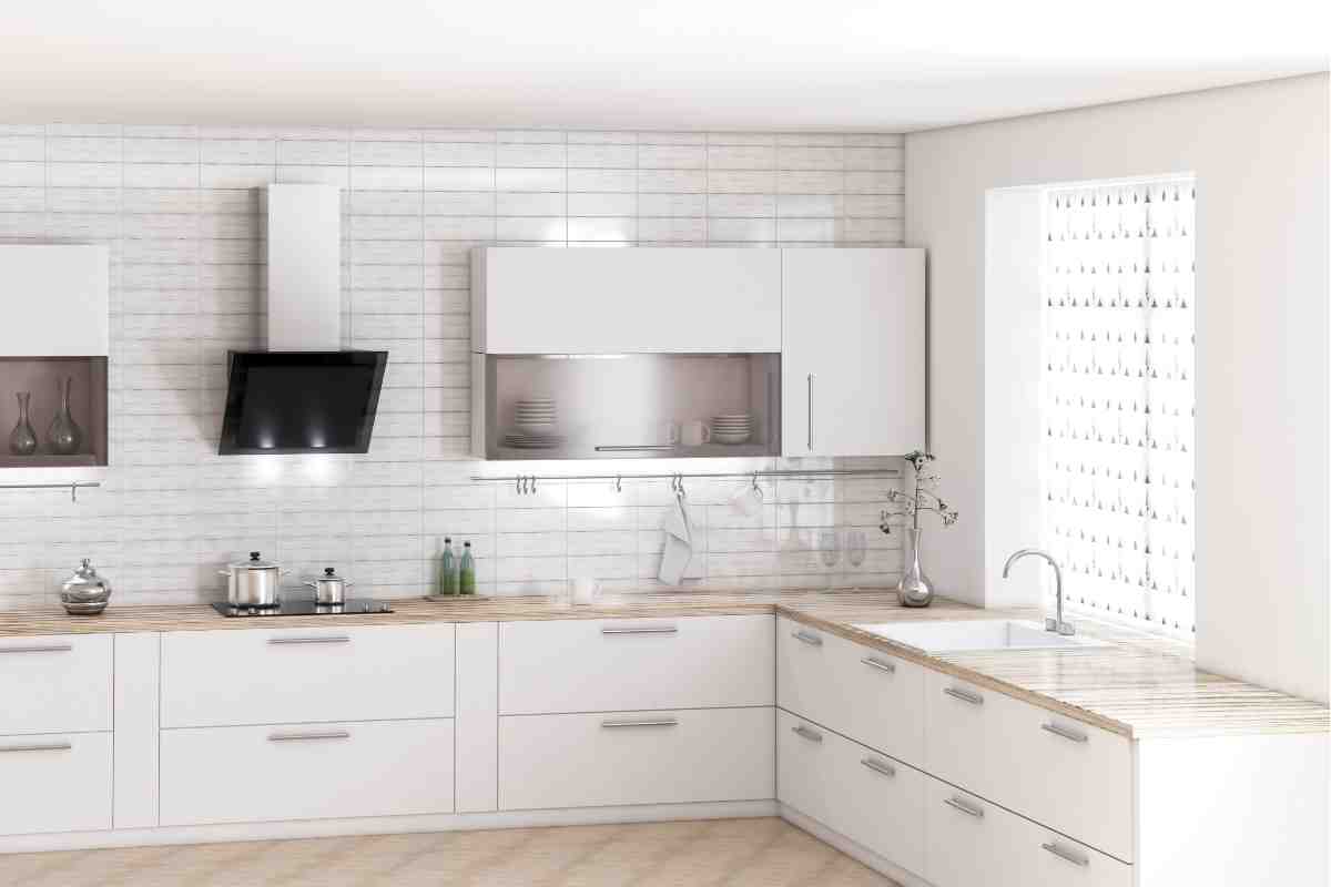 cucina ad angolo stile moderno con ante di colore bianco e cappa di design