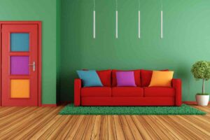 divano di colore rosso davanti a parete verde e pavimento in parquet