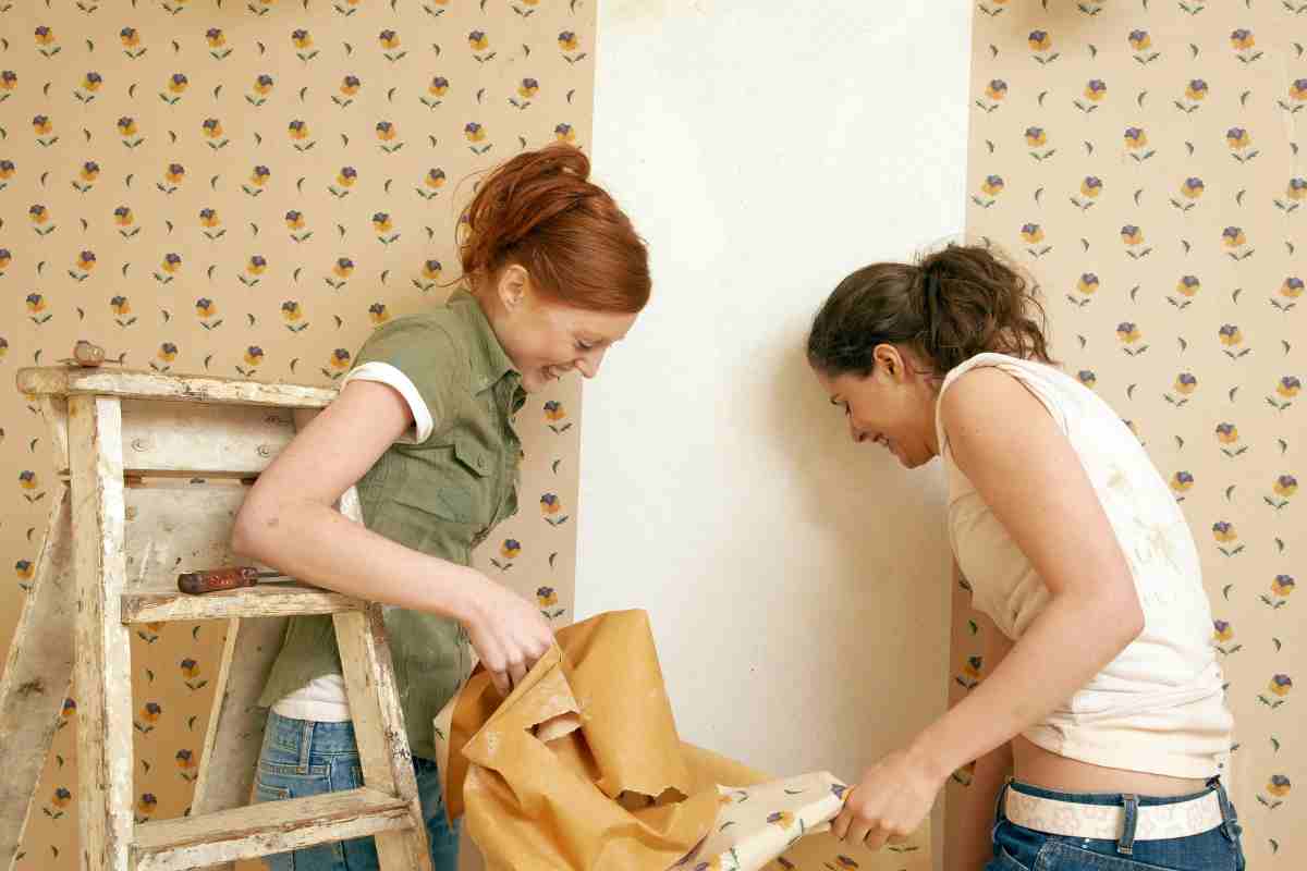 ragazze tolgono la carta da parati