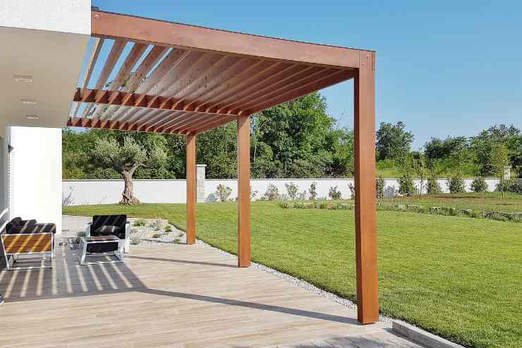 Porzione di giardino con pergola addossata in legno