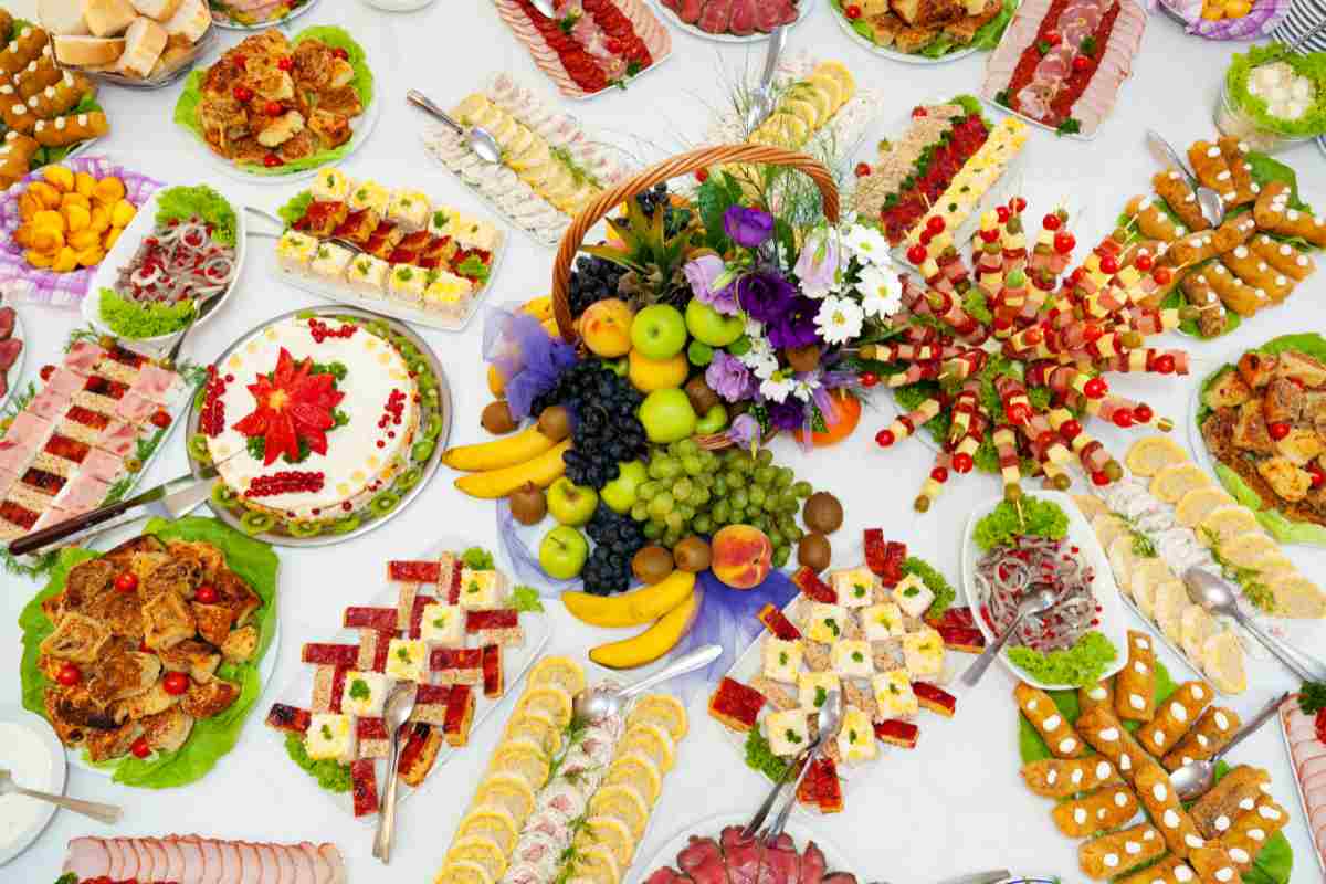 tavolo a buffet per l'aperitivo con vassoi di snack salati e dolci