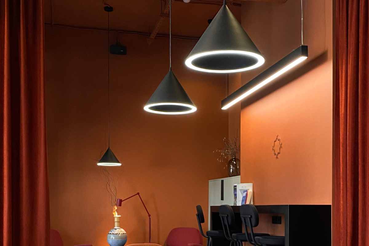 tre lampade a sospensione coniche con luce led sulla circonferenza in un living moderno