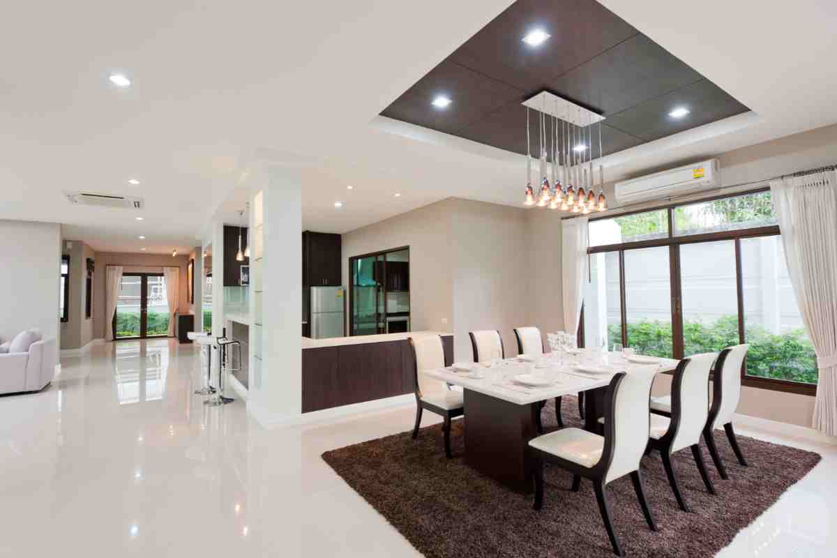 sala da pranzo moderna illuminata con faretti e lampade a sospensione