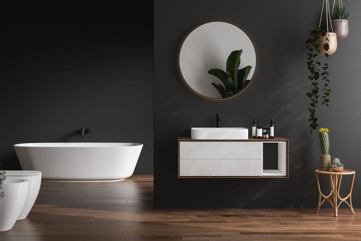 bagno con sanitari sospesi di colore bianco, pavimento con parquet, piante verdi e pareti di colore nero