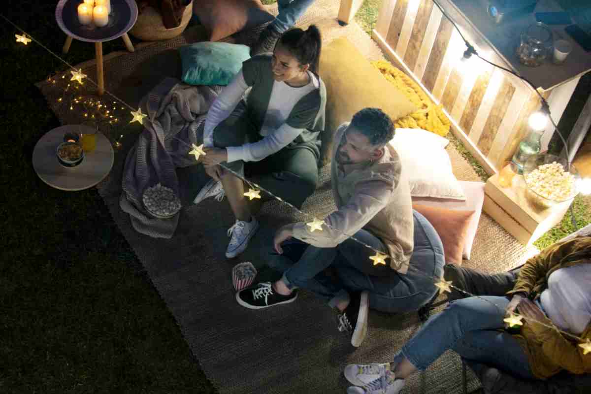 ragazzi sorridenti in relax sul terrazzo illuminato