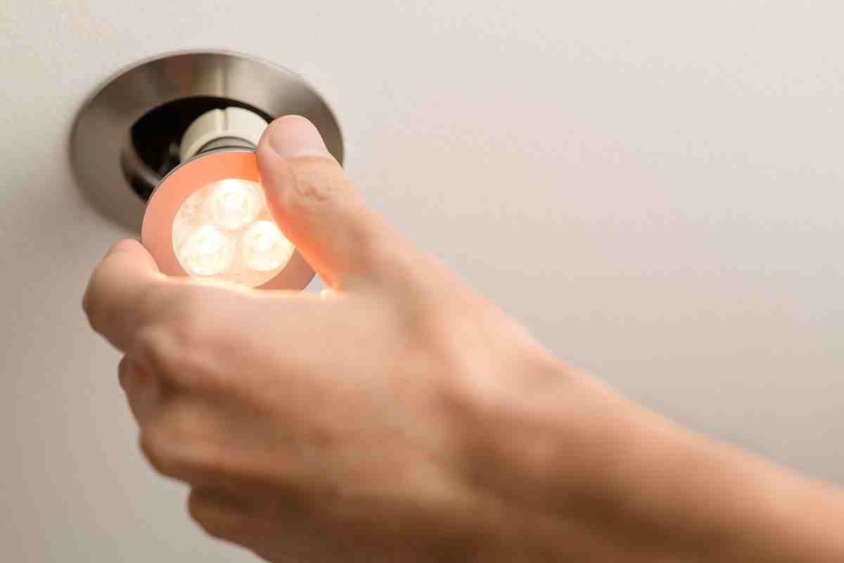 mano monta una lampada LED al faretto 