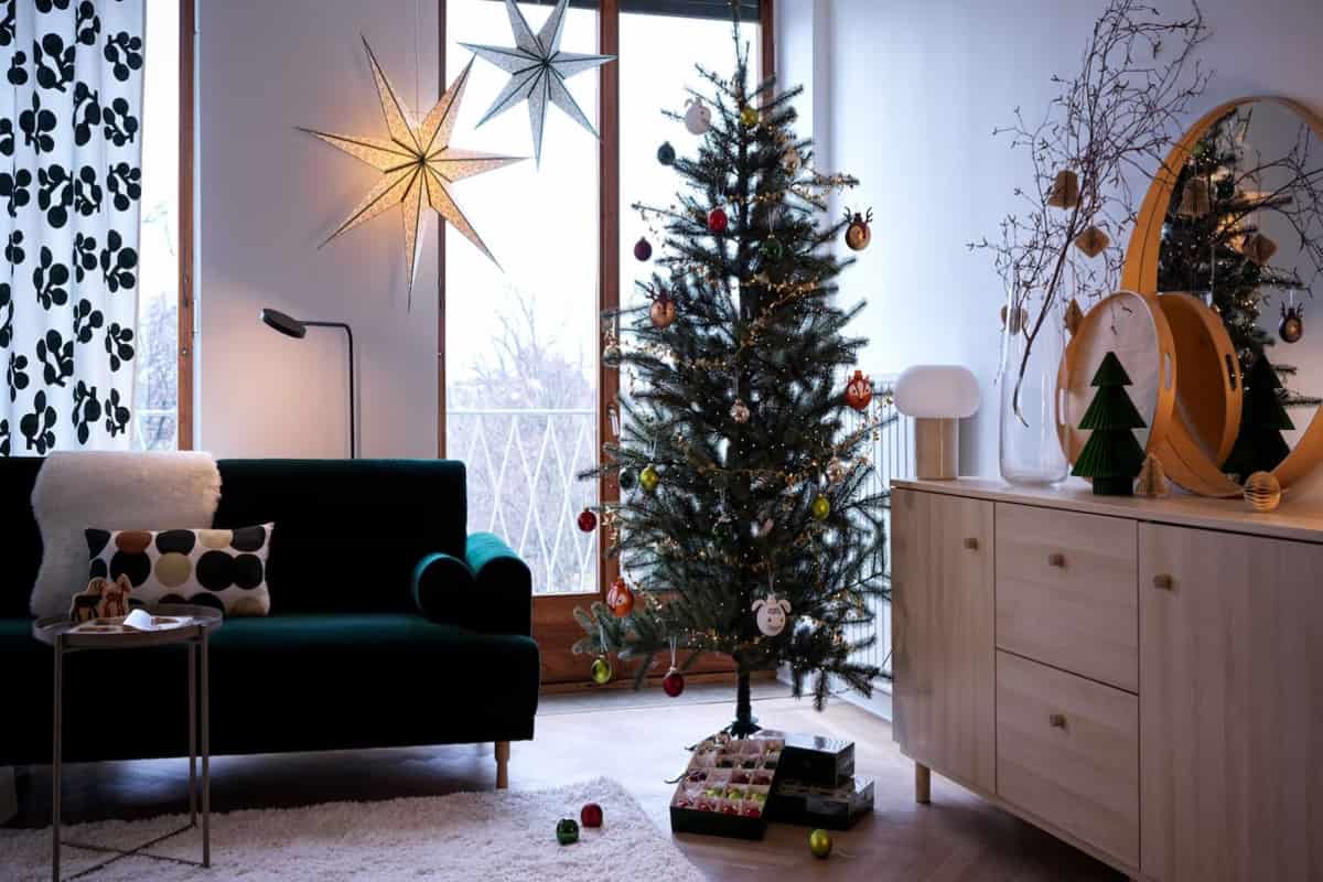 soggiorno con decorazioni natalizie di Ikea e albero di Natale in primo piano 