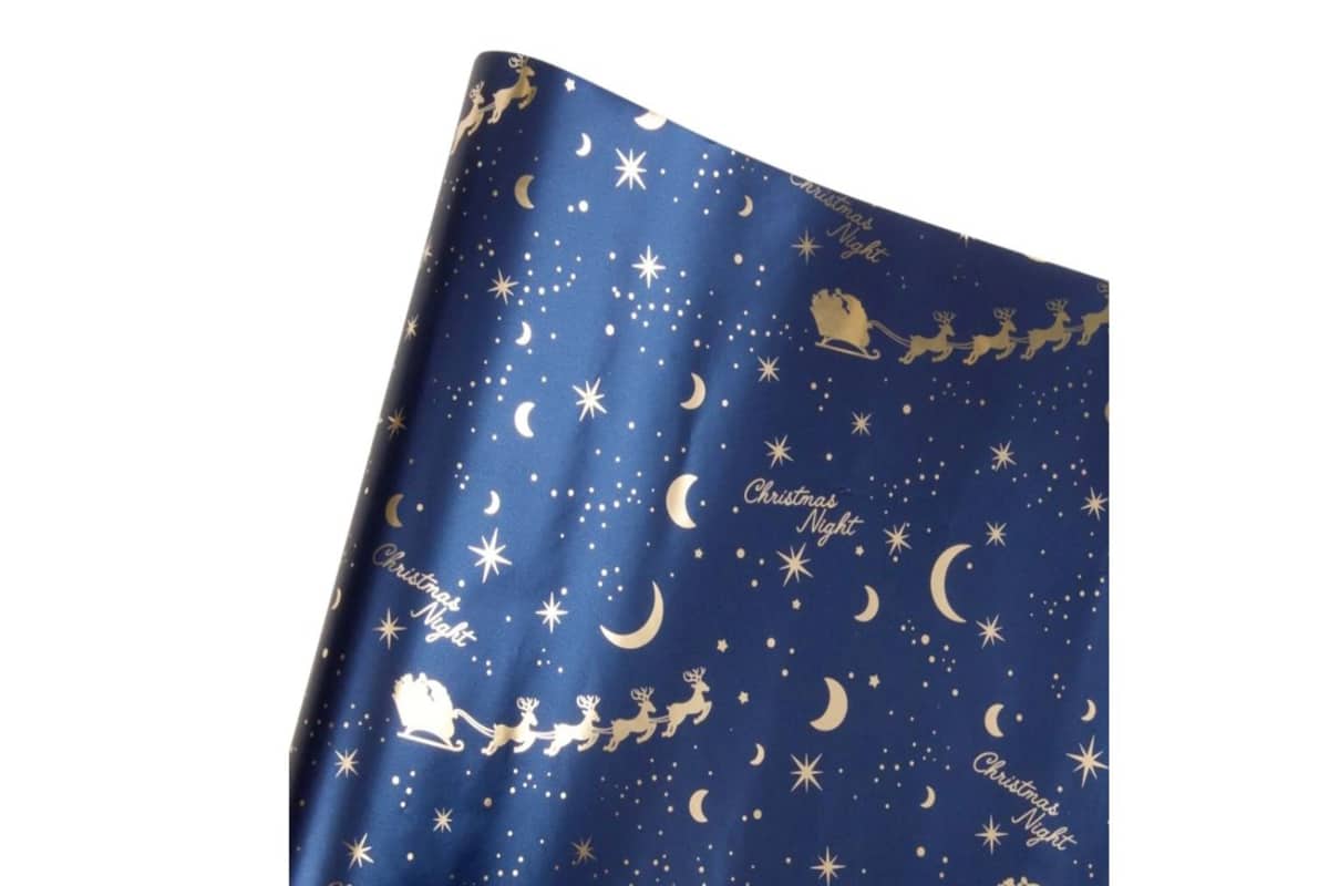 carta per i regali di colore blu con lune e stelle stampate di colore oro