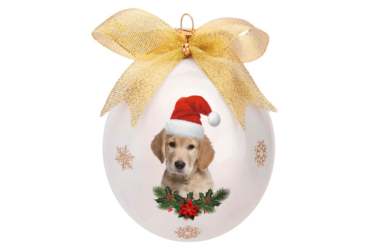 pallina di natale con base di colore bianca, con un cane cucciolo disegnato, che indossa il cappello di babbo natale e un fiocco dorato per appendere la pallina