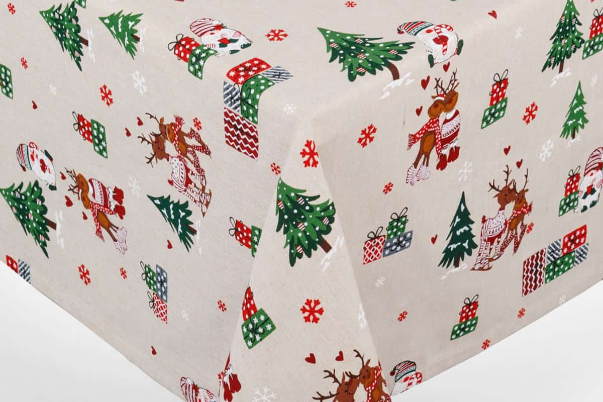 tovaglia con base di colore beige e stampe natalizie come alberi di natale e pacchi regalo 