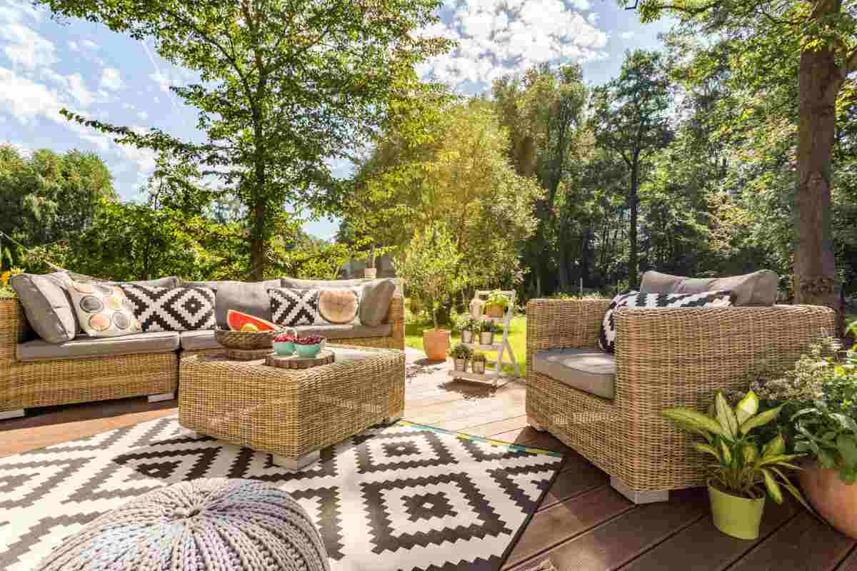 patio di un giardino immerso nella natura con arredi in rattan