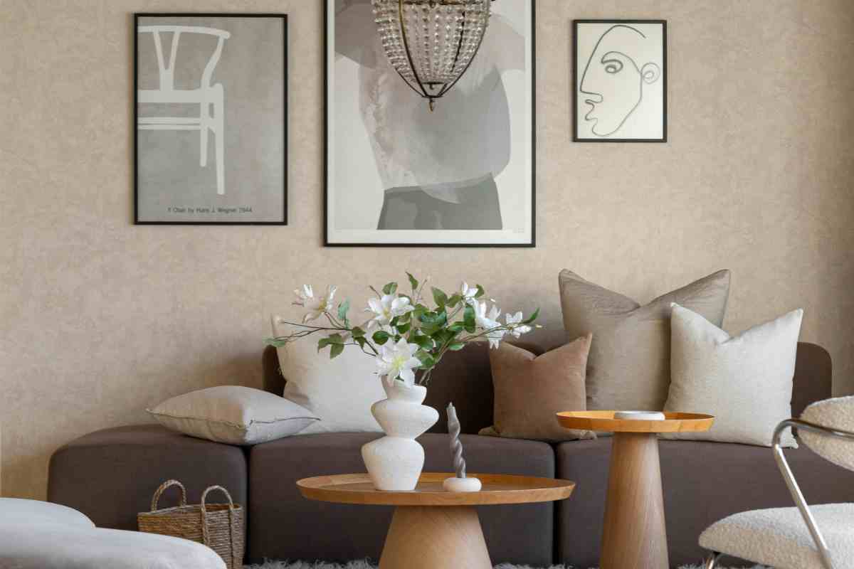 salotto con divano grigio e cuscini beige e tavolini rotondi