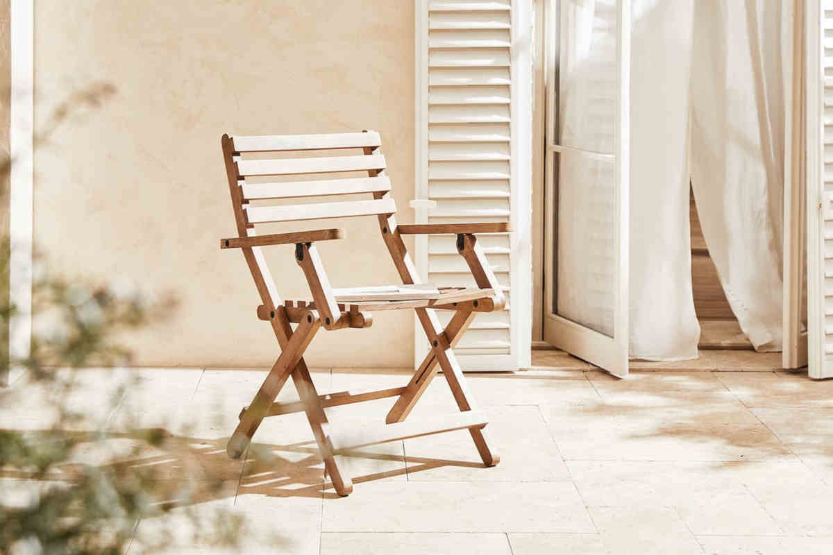 terrazzo con al centro una sedia pieghevole in legno di mango zara home