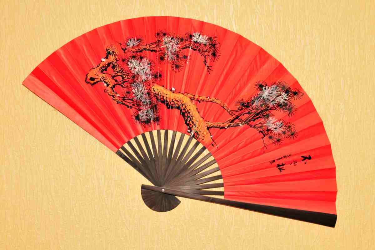 un ventaglio rosso con decorazioni tradizionali cinesi