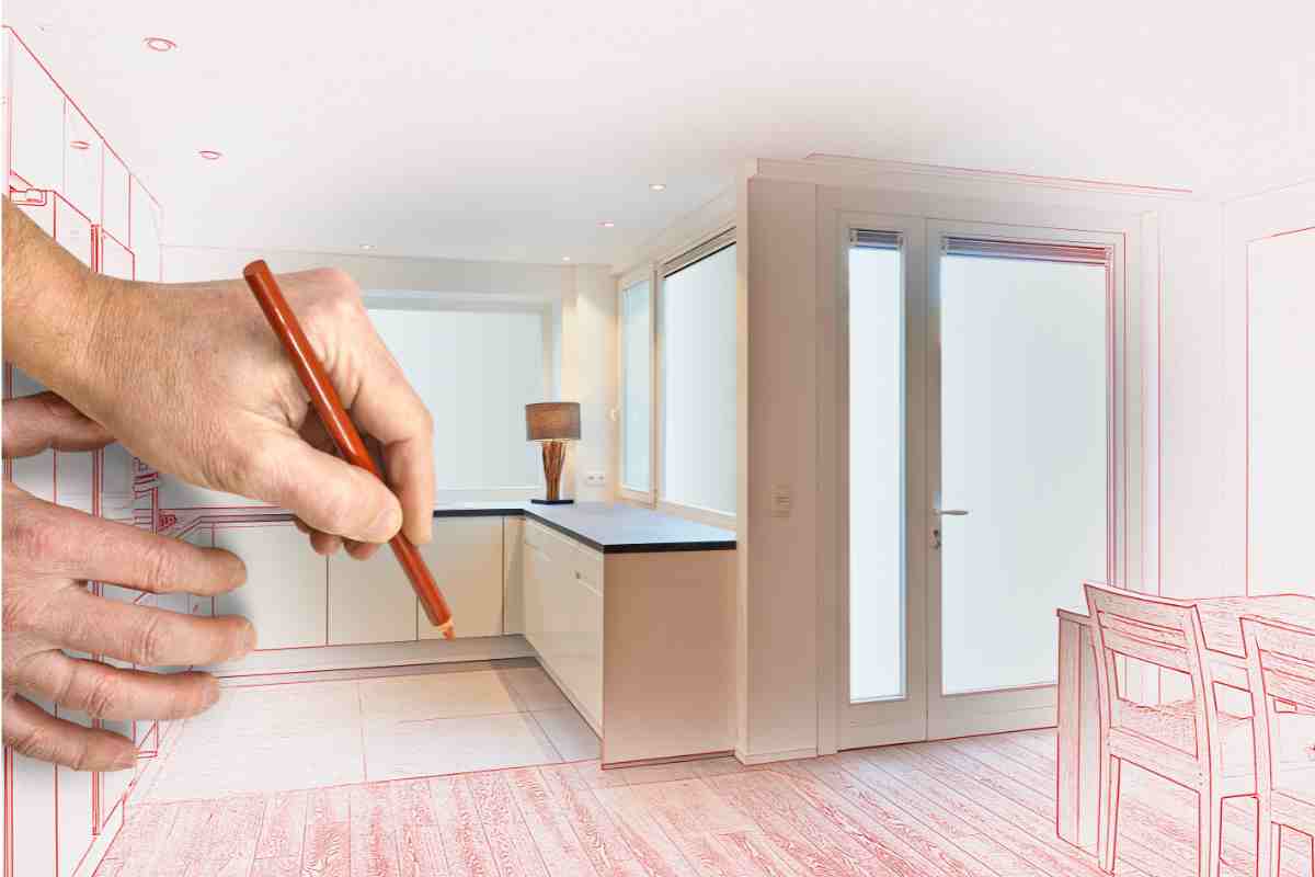 mano con matita su disegno di una cucina in ristrutturazione