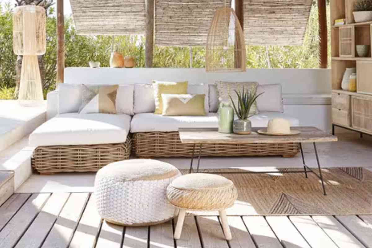 giardino arredato con divano da esterno, tavolino e pouf