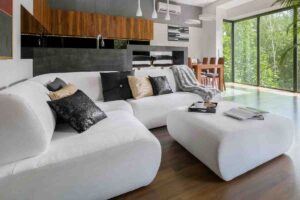 divano bianco ad angolo con pouf design moderno
