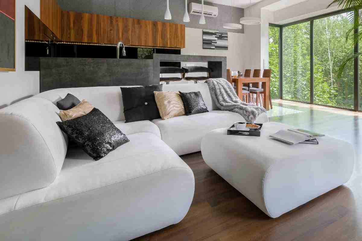 divano bianco ad angolo con pouf design moderno