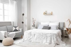 camera degli ospiti arredata con divano e letto matrimoniale, pouf e tappeto