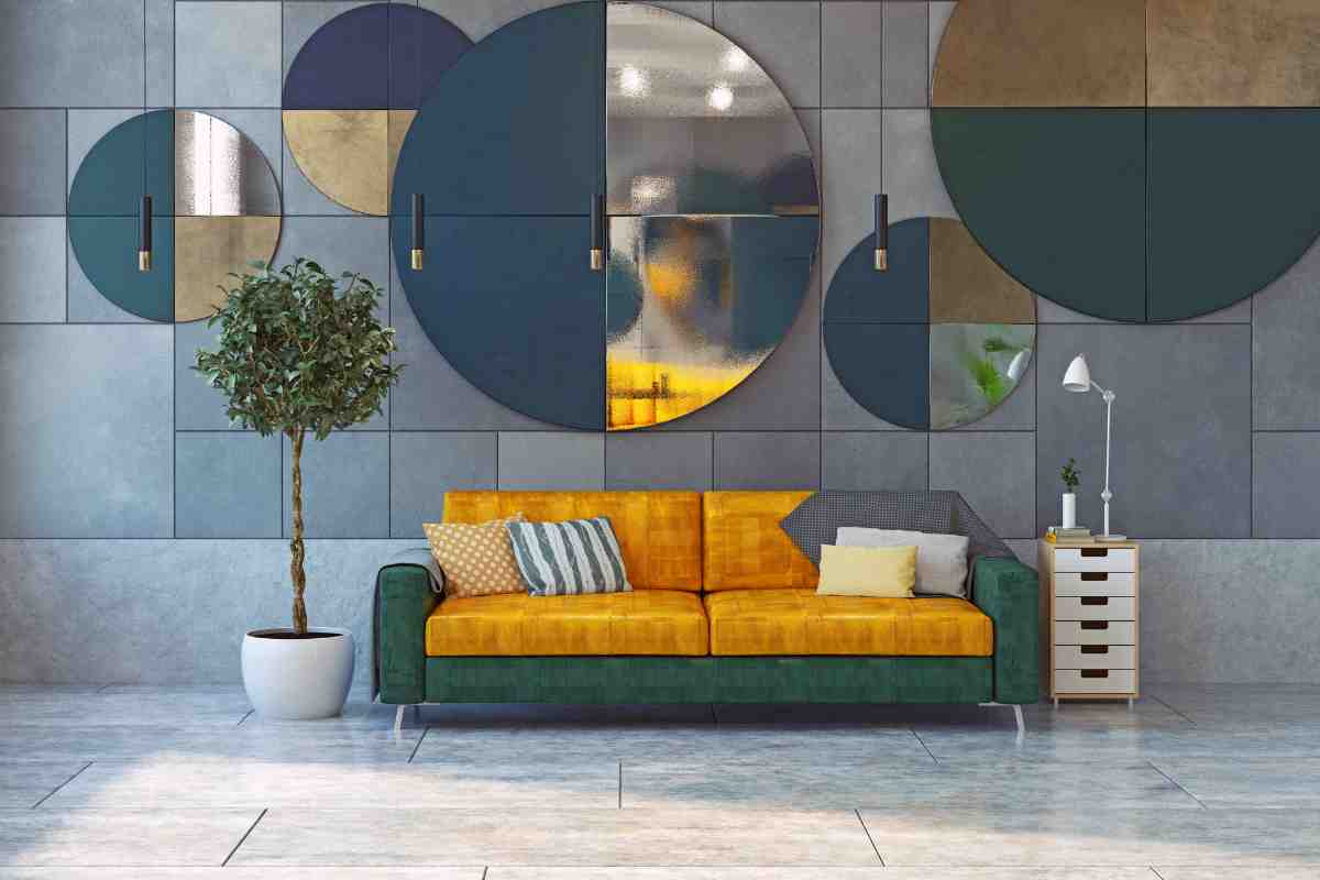 divano verde e giallo davanti a parete con decorazioni a specchio rotonde in stile vintage