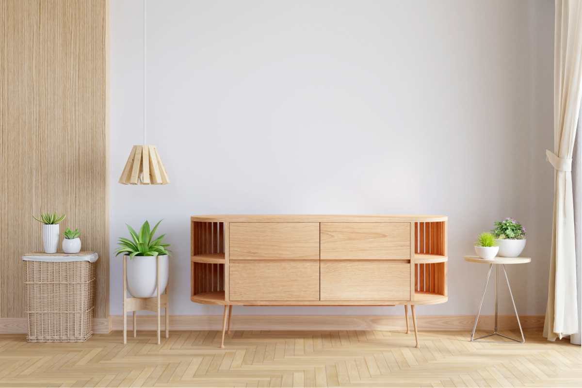 una madia in legno dal design moderno con vani laterali aperti vicino a pianta e a tavolinetto