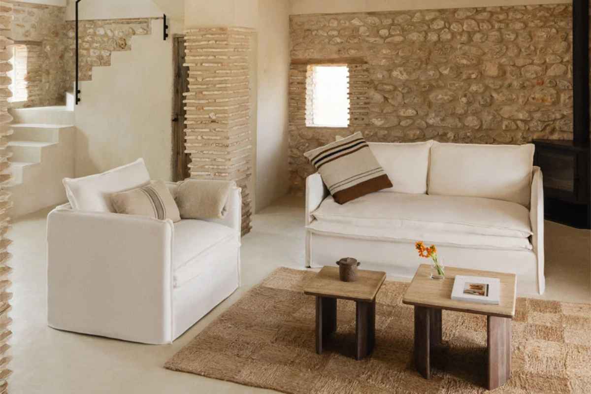 soggiorno rustico con pietre a vista e divano bianco